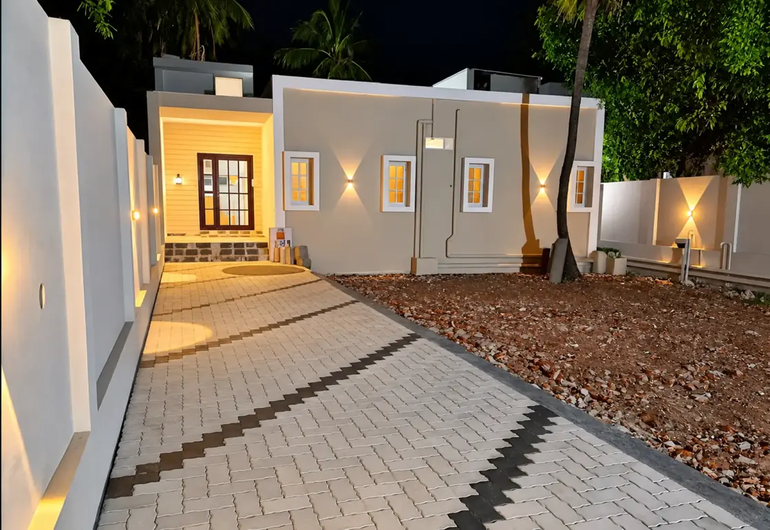 விளக்குகள் ஒளிரும் நடைபாதையுடன் இரவில் The Heritage Inn நாகூர் வெளிப்புறம்